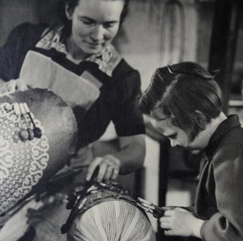 Maminka krajkářka učí dceru paličkovat (40. léta 20. století)